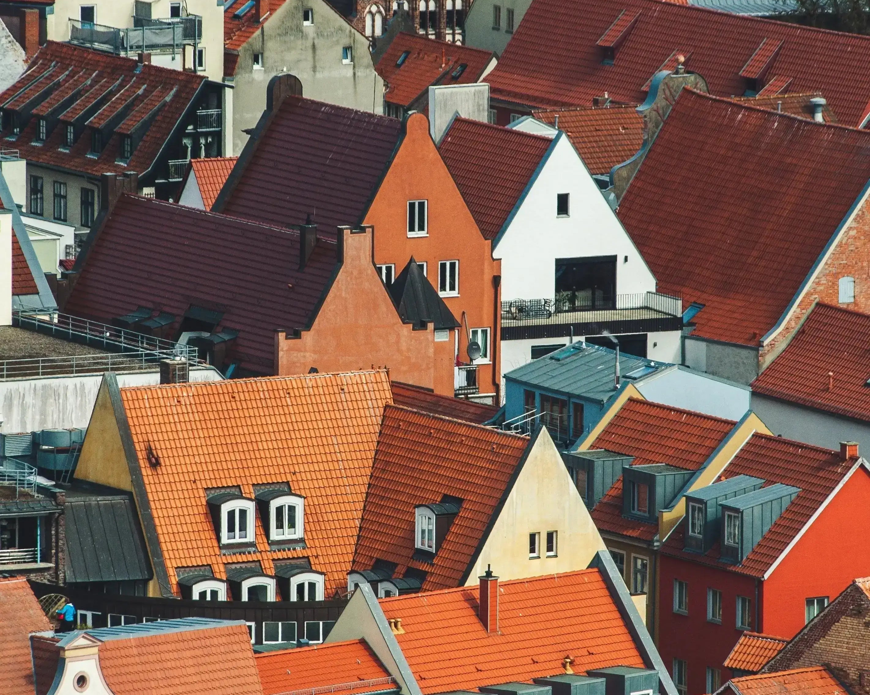 Utsikt över hustak i en europeisk stad med orange och röda takpannor.