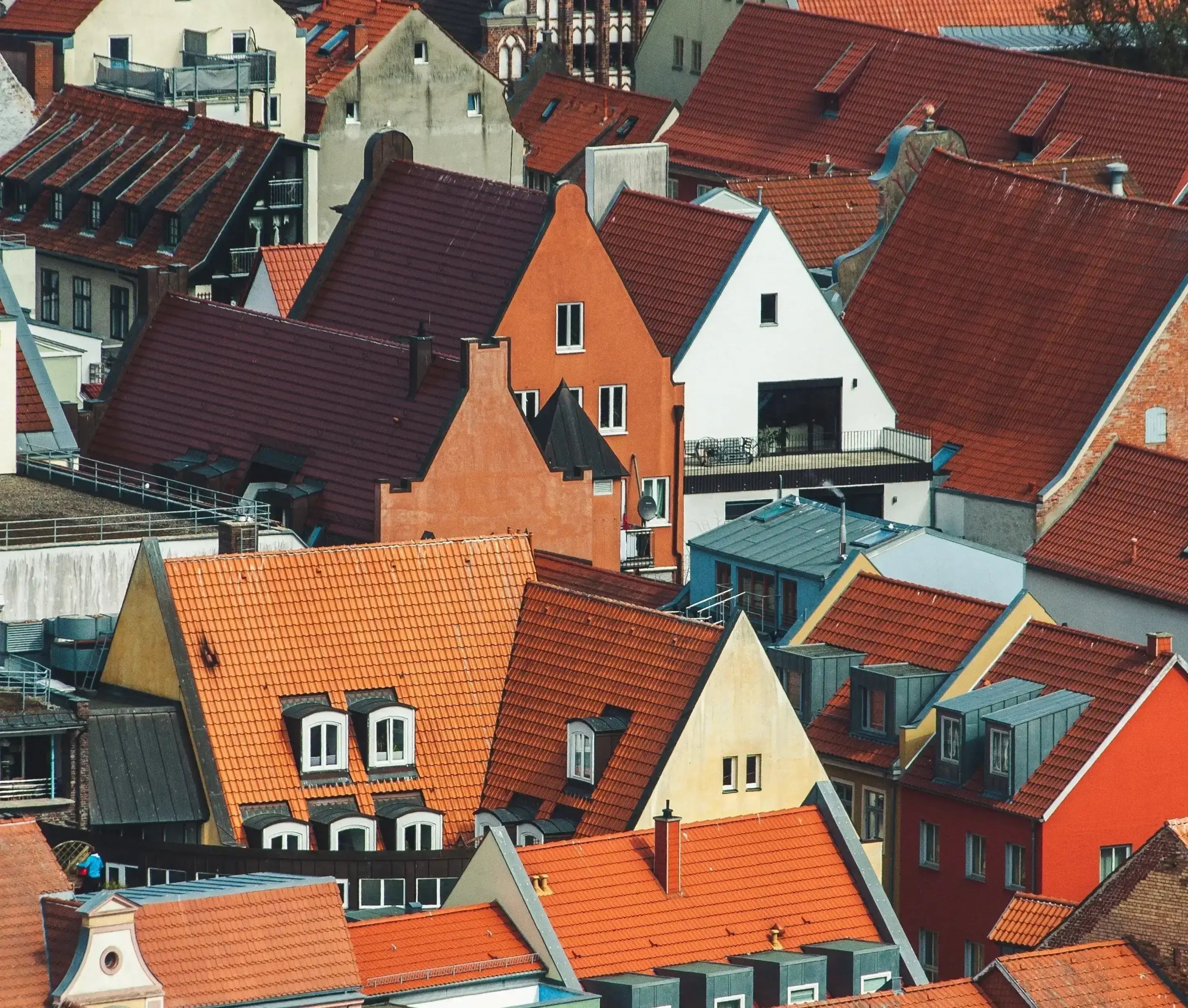 Utsikt över hustak i en europeisk stad med orange och röda takpannor.