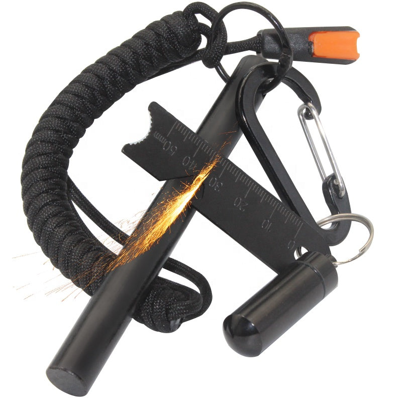 Ett svart tändstål med gnistor, fäst vid en multiverktyg med karbinhake och paracord.
